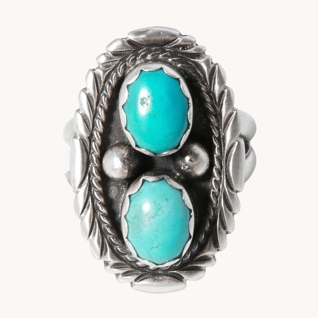 Two-Stone Turquoise Ring with Patterned Border, made of sterling silver by T.Skies, showcasing vibrant turquoise stones.