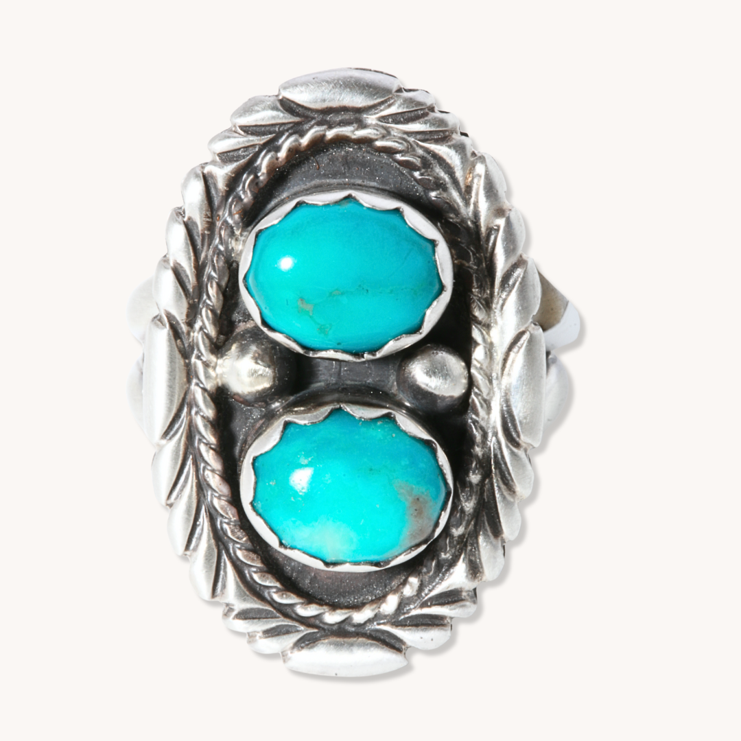 Two-Stone Turquoise Ring by T.Skies, featuring turquoise stones set in sterling silver with a patterned border.