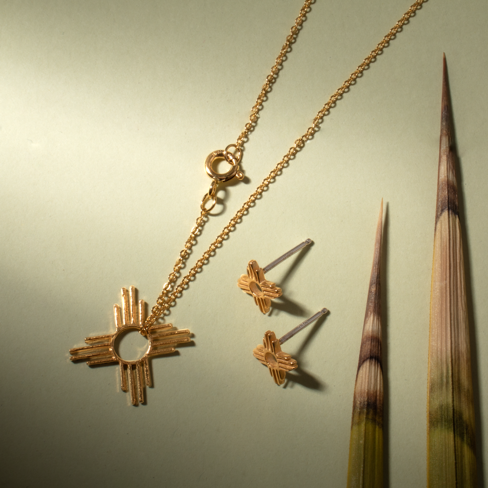 Enchantment: Petite Pendant & Zia Studs in sterling silver, featuring a geometric pendant and floral stud earrings.