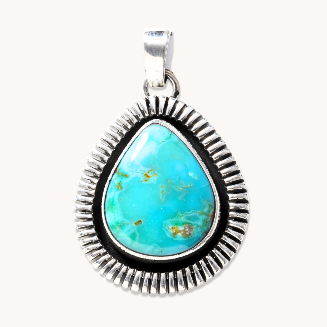 T.Skies Turquoise Pendant featuring a saw-work border in sterling silver, showcasing a vibrant turquoise stone.