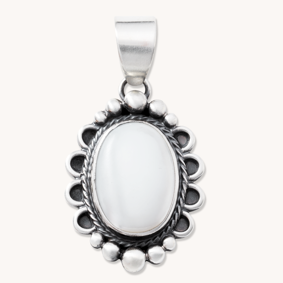 T.Skies delicate Mother of Pearl pendant with silver button accents, featuring an oval shape and intricate detailing.