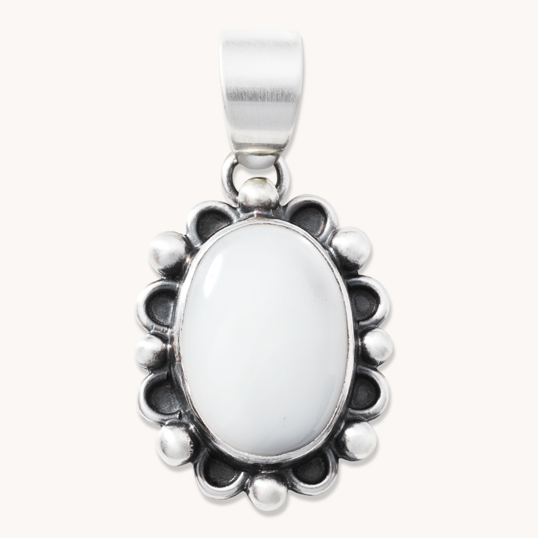 T.Skies delicate Mother of Pearl pendant with silver button accents, featuring an oval shape and intricate detailing.
