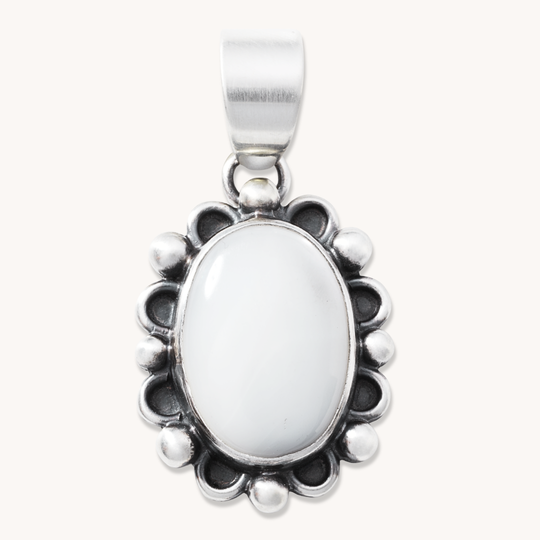 T.Skies delicate Mother of Pearl pendant with silver button accents, featuring an oval shape and intricate detailing.