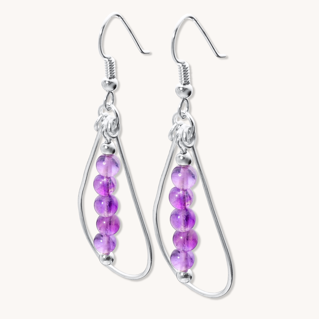 Bead Maiden: Wrapped Intention Earrings made of sterling silver with purple beads, showcasing a teardrop design.