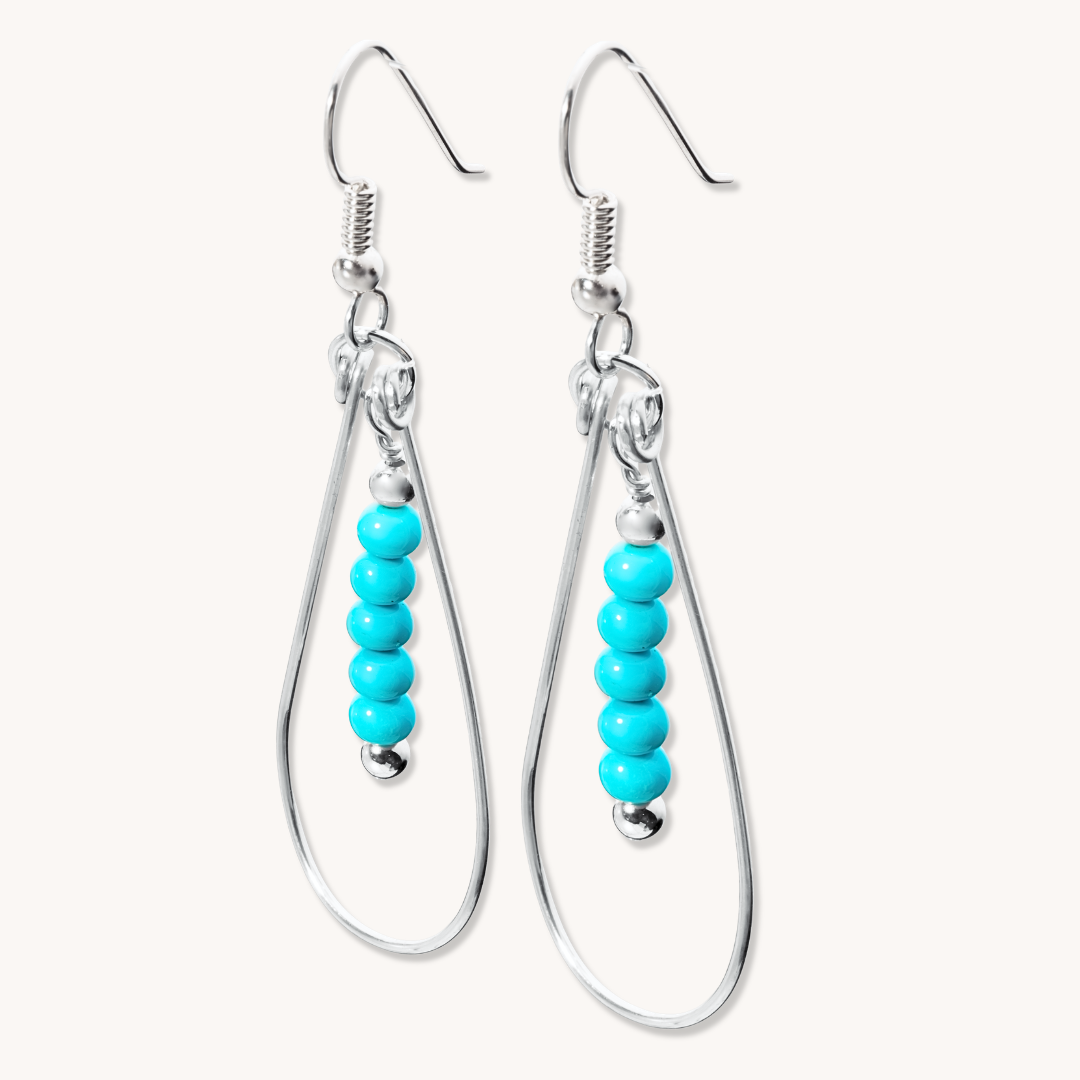 Bead Maiden: Wrapped Intention Earrings made of sterling silver with turquoise beads, featuring a teardrop design.
