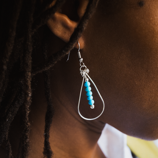 Bead Maiden: Wrapped Intention Earrings in sterling silver featuring turquoise beads, worn on a model's ear.