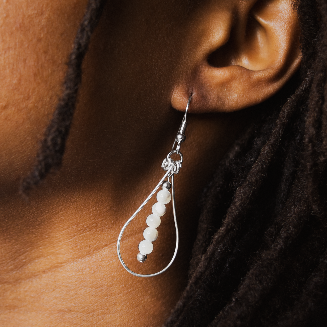 Bead Maiden: Wrapped Intention Earrings in sterling silver with white beads, elegantly hanging from the ear.