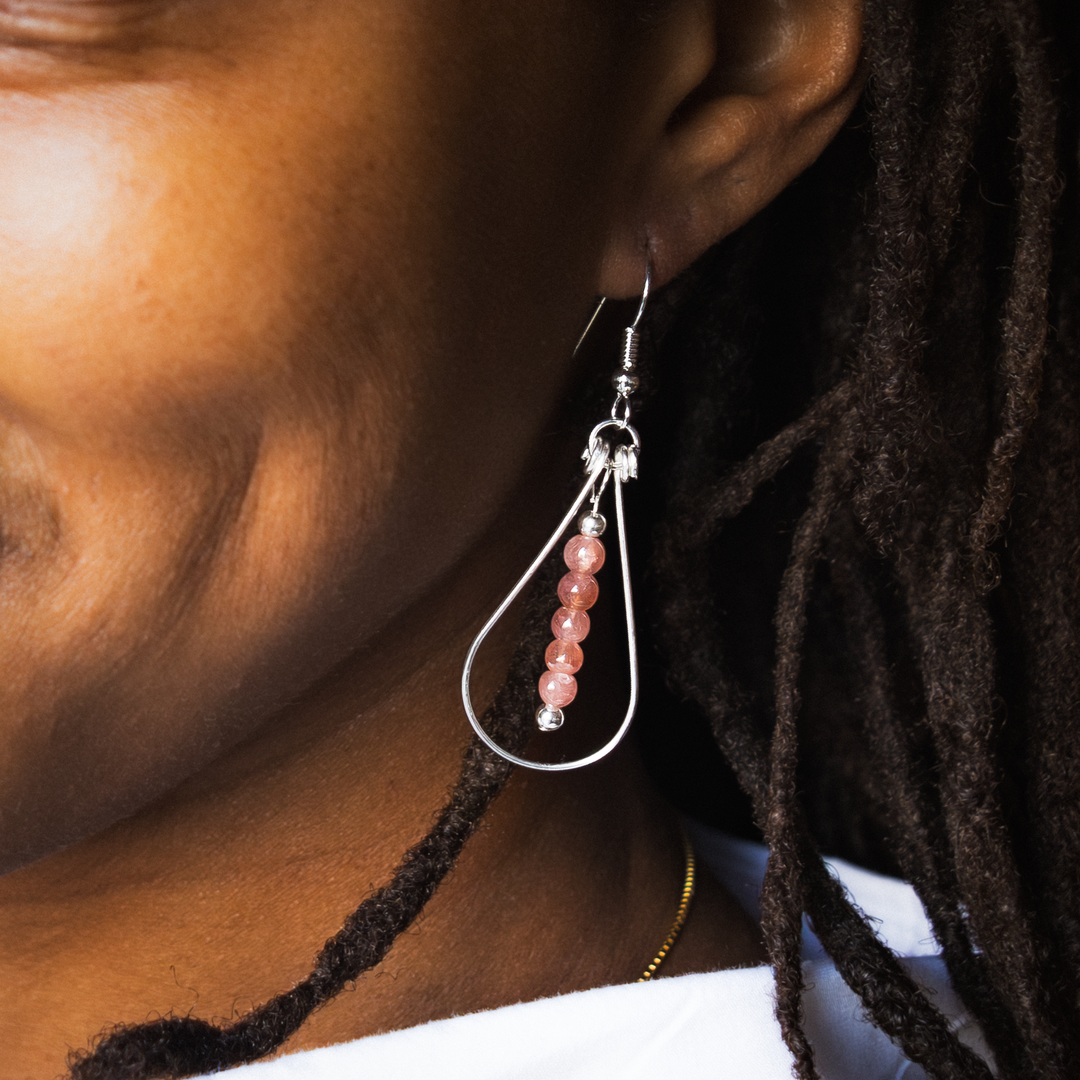 Bead Maiden: Wrapped Intention Earrings in sterling silver with pink beads, worn on a model's ear.