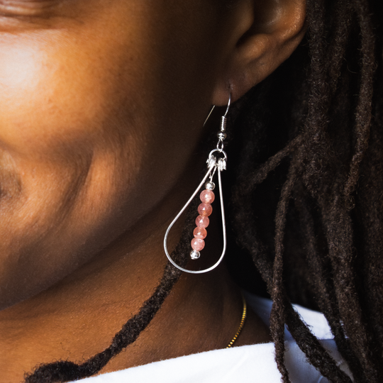 Bead Maiden: Wrapped Intention Earrings in sterling silver with pink beads, worn on a model's ear.