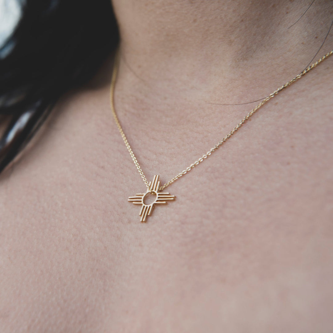 Enchantment: Petite Pendant & Zia Studs, sterling silver jewelry featuring a Zia symbol pendant on a delicate chain.