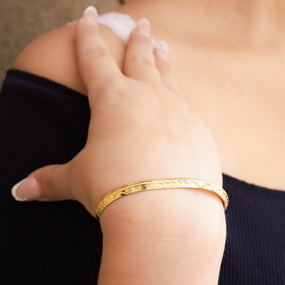 Stamp Dancer: Sagebrush Stacker Bracelet in sterling silver, worn on a hand against a dark top, showcasing intricate designs.
