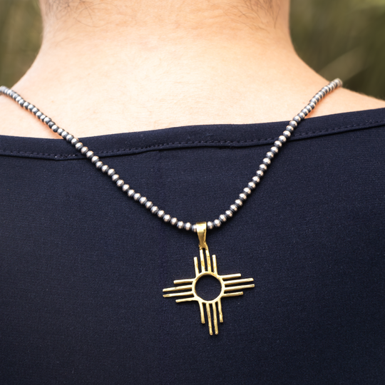 Enchantment: Zia Pendant in sterling silver, featuring a gold-tone Zia symbol on a beaded necklace.