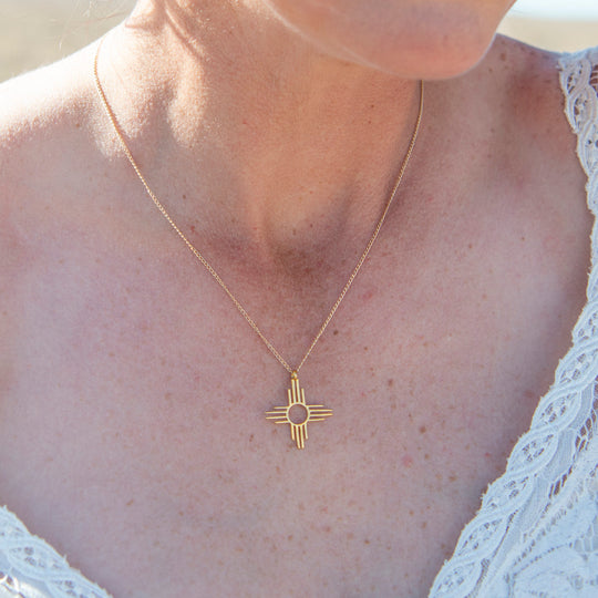 Enchantment: Zia Dangle Necklace in sterling silver, featuring a Zia sun symbol on a delicate chain.