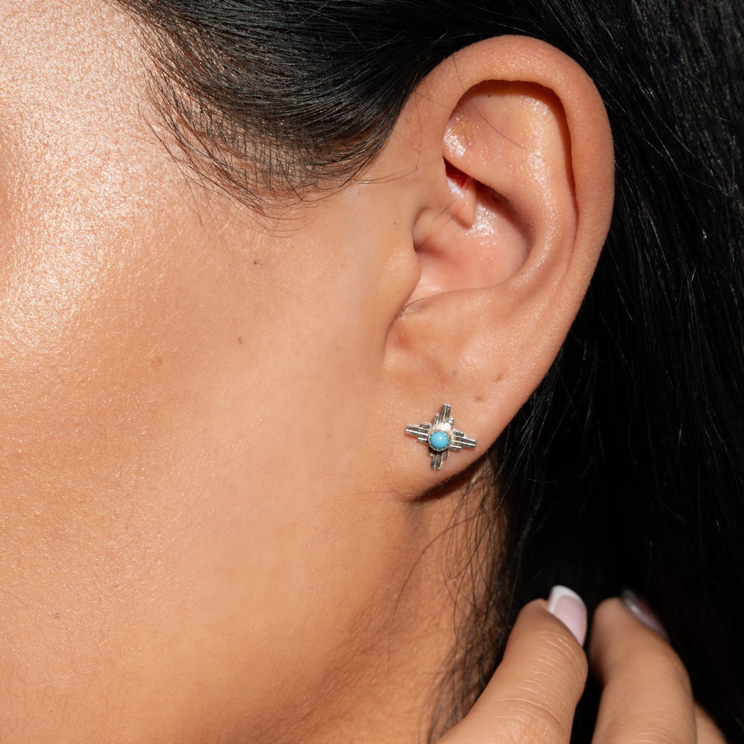 Enchantment: Sunrise Zia Stud Earring Trio in sterling silver featuring turquoise accents, worn on a model's ear.