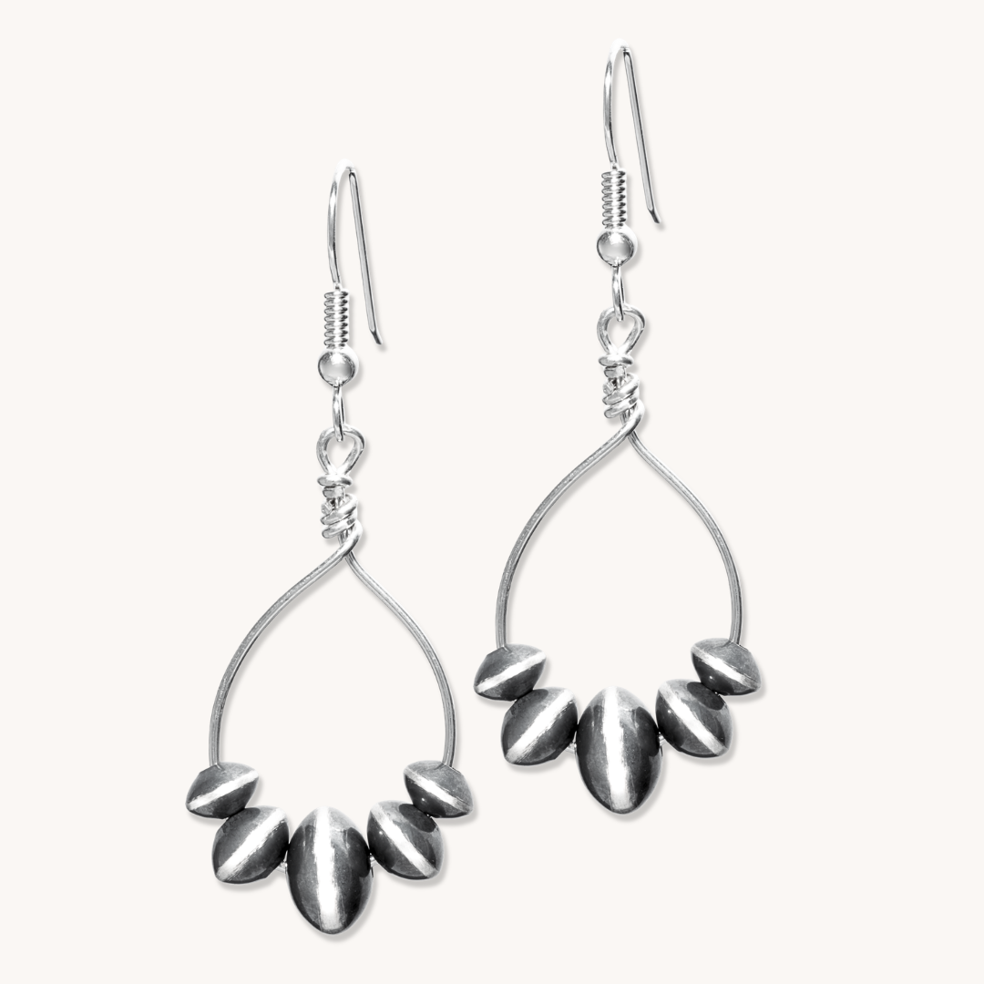 Desert Blossom: Lotus Flower Earrings in sterling silver, featuring a delicate design with teardrop shapes.