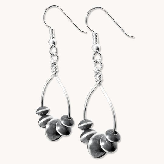 Desert Blossom: Lotus Flower Earrings made of sterling silver, featuring a unique teardrop design with layered circular elements.