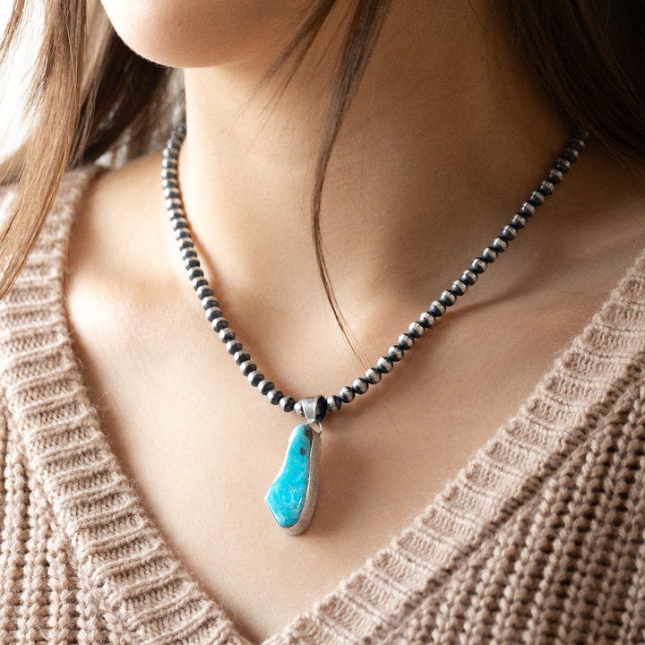 Radiante: Mystery Turquoise Pendant in sterling silver, featuring a unique turquoise stone on a beaded necklace.